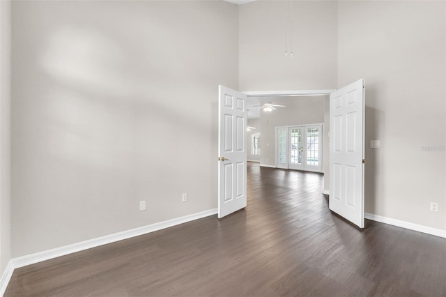 2675 Bond St, Clermont, FL 34711 - empty room with dark wood-type flooring, ceiling fan, a towering ceiling, and french doors