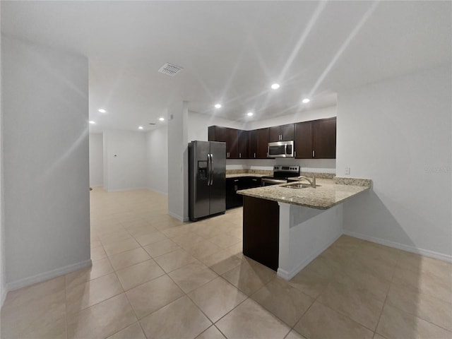 326 Charles Dr, Deland, FL 32724 - kitchen with appliances with stainless steel finishes, recessed lighting, a peninsula, dark brown cabinets, and light stone counters