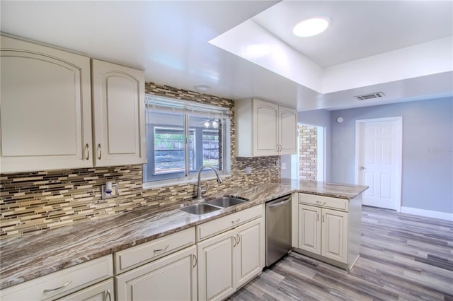 2005 Dalton Ave, Deltona, FL 32725 - kitchen with stainless steel dishwasher, tasteful backsplash, light wood-type flooring, and a peninsula