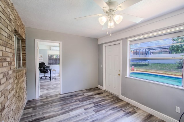 2005 Dalton Ave, Deltona, FL 32725 - foyer entrance featuring wood finished floors, a ceiling fan, brick wall, and a textured ceiling