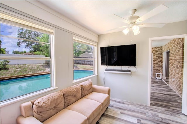 2005 Dalton Ave, Deltona, FL 32725 - living area featuring wood finished floors, ceiling fan, and brick wall