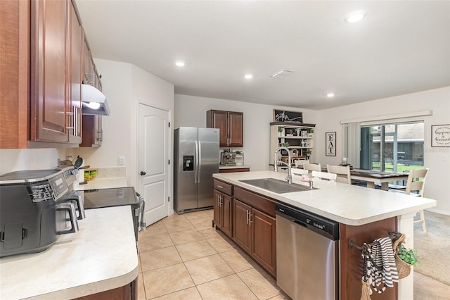 1010 Morvan Ln, Kissimmee, FL 34759 - kitchen featuring appliances with stainless steel finishes, light countertops, under cabinet range hood, an island with sink, and recessed lighting