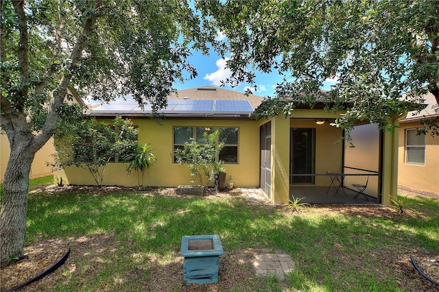 519 Cadiz Dr, Davenport, FL 33837 - rear view of house featuring roof mounted solar panels, stucco siding, and a yard