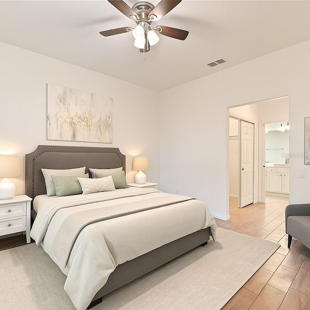 519 Cadiz Dr, Davenport, FL 33837 - bedroom featuring wood tiled floors, connected bathroom, and a ceiling fan