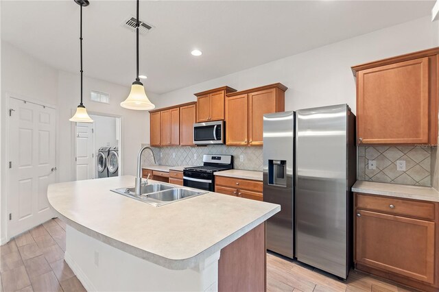 519 Cadiz Dr, Davenport, FL 33837 - kitchen with appliances with stainless steel finishes, washing machine and clothes dryer, brown cabinetry, backsplash, and recessed lighting
