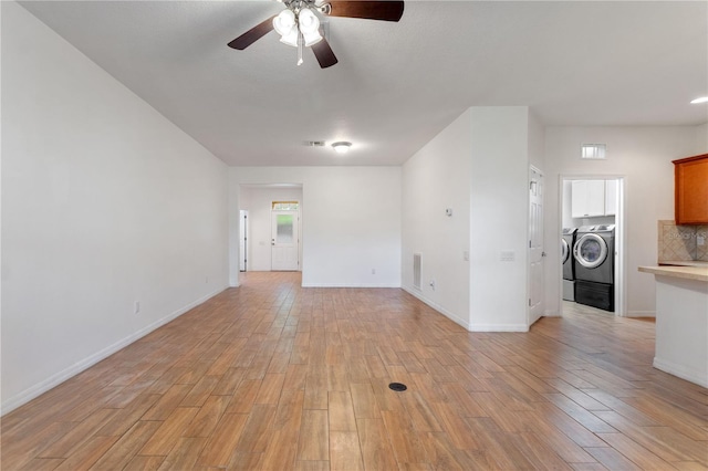 519 Cadiz Dr, Davenport, FL 33837 - unfurnished living room with ceiling fan, light wood-style flooring, and washing machine and clothes dryer