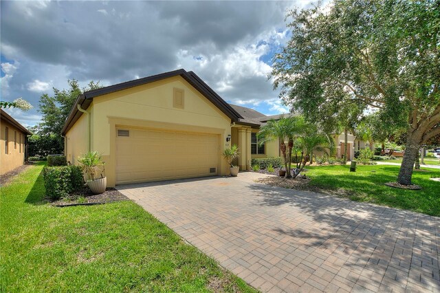 519 Cadiz Dr, Davenport, FL 33837 - view of front of property featuring a garage, stucco siding, a front yard, and decorative driveway
