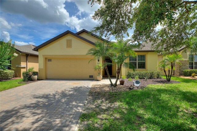 519 Cadiz Dr, Davenport, FL 33837 - single story home with stucco siding, an attached garage, decorative driveway, and a front lawn