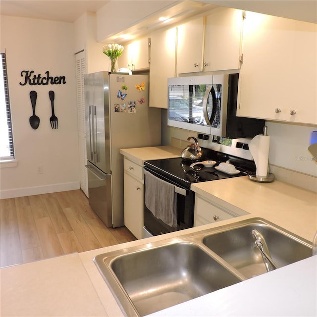 2480 Tahoe Cir Unit 2480, Winter Park, FL 32792 - kitchen with stainless steel appliances, light wood-style flooring, light countertops, and white cabinets