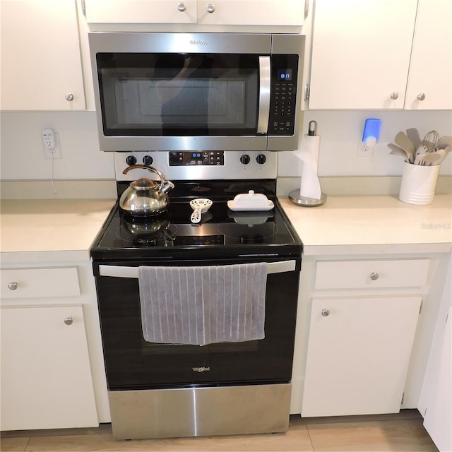 2480 Tahoe Cir Unit 2480, Winter Park, FL 32792 - kitchen featuring appliances with stainless steel finishes, light countertops, and white cabinets