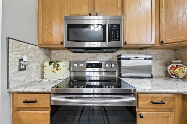 1430 Challenger Ave, Davenport, FL 33897 - kitchen with appliances with stainless steel finishes, tile patterned flooring, backsplash, and light stone counters