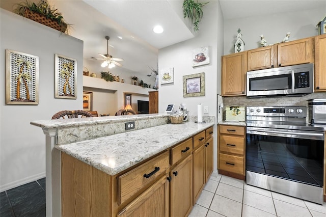 1430 Challenger Ave, Davenport, FL 33897 - kitchen featuring appliances with stainless steel finishes, a peninsula, ceiling fan, light stone counters, and light tile patterned floors
