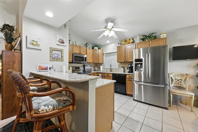 1430 Challenger Ave, Davenport, FL 33897 - kitchen featuring stainless steel appliances, vaulted ceiling, a peninsula, a ceiling fan, and light tile patterned floors