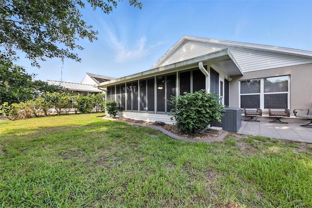 1430 Challenger Ave, Davenport, FL 33897 - rear view of house featuring a sunroom, a lawn, and a patio