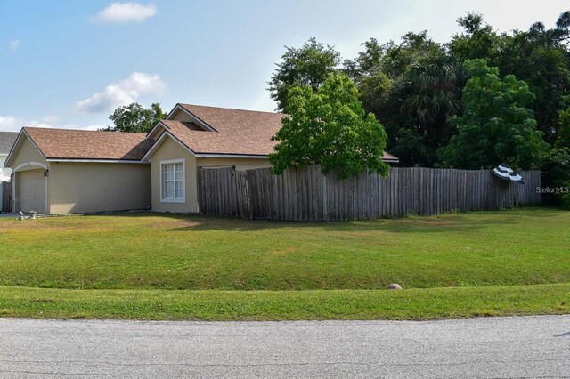 1436 Swan Ct, Kissimmee, FL 34759 - view of side of home featuring stucco siding, a garage, and a shingled roof