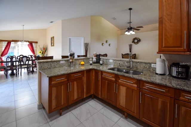 1436 Swan Ct, Kissimmee, FL 34759 - kitchen with lofted ceiling, ceiling fan, light stone counters, decorative light fixtures, and a peninsula