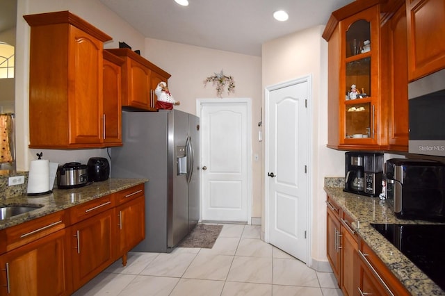 1436 Swan Ct, Kissimmee, FL 34759 - kitchen featuring appliances with stainless steel finishes, glass insert cabinets, stone countertops, recessed lighting, and brown cabinetry