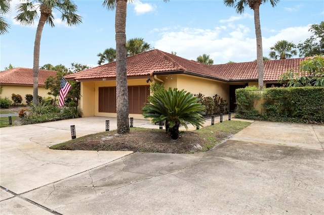 5057 Maui Cir Unit 15, Orlando, FL 32808 - view of front of house featuring driveway, stucco siding, an attached garage, and a tile roof