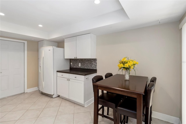 5057 Maui Cir Unit 15, Orlando, FL 32808 - kitchen featuring white refrigerator with ice dispenser, dark countertops, recessed lighting, backsplash, and white cabinetry