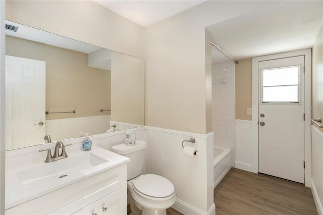 5057 Maui Cir Unit 15, Orlando, FL 32808 - bathroom featuring vanity, a wainscoted wall, wood finished floors, and shower / bath combination