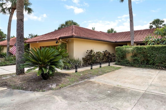 5057 Maui Cir Unit 15, Orlando, FL 32808 - view of side of property with a tile roof, stucco siding, and a patio area