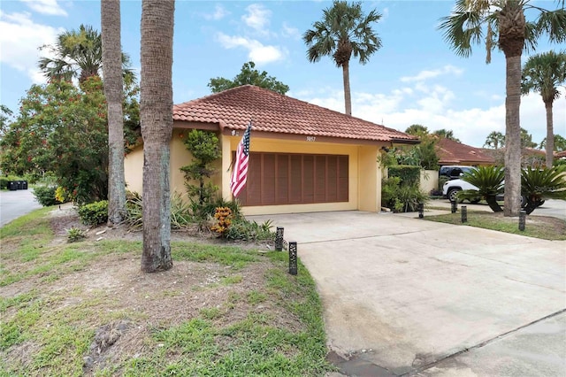 5057 Maui Cir Unit 15, Orlando, FL 32808 - view of front facade featuring a tiled roof, stucco siding, an attached garage, and driveway