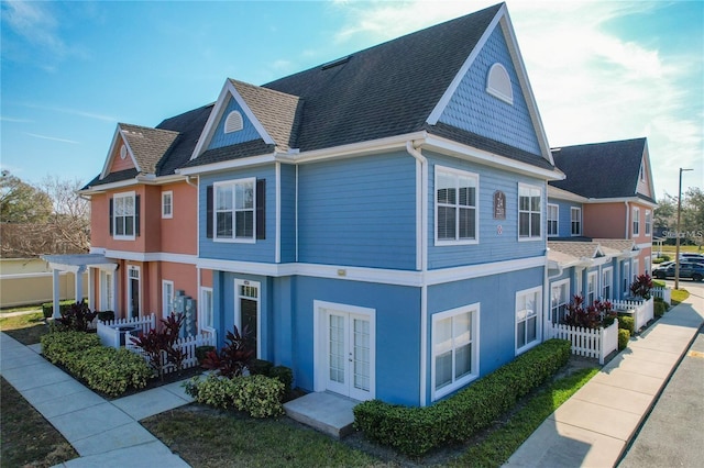 4019 Venetian Bay Dr Unit 107, Kissimmee, FL 34741 - view of property exterior featuring french doors, stucco siding, and roof with shingles
