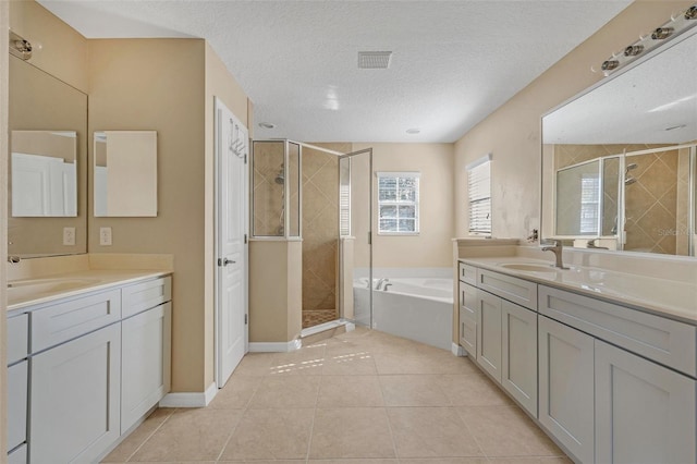 7184 Maleberry Run, Winter Garden, FL 34787 - full bath with a stall shower, two vanities, a bath, tile patterned flooring, and a textured ceiling