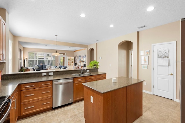 12868 Holdenbury Ln, Windermere, FL 34786 - kitchen featuring dishwasher, brown cabinetry, arched walkways, stove, and a center island