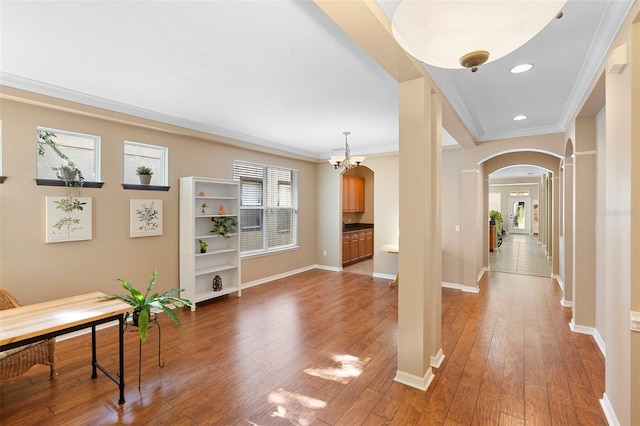 12868 Holdenbury Ln, Windermere, FL 34786 - entrance foyer with arched walkways, crown molding, light wood-style flooring, a chandelier, and ornate columns