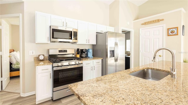 131 Sonja Cir, Davenport, FL 33897 - kitchen featuring appliances with stainless steel finishes, light wood-style floors, white cabinetry, and light stone counters
