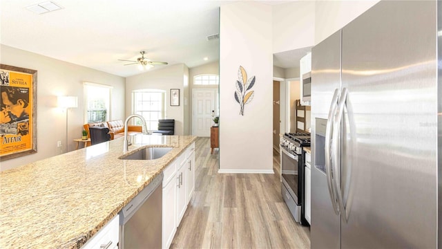 131 Sonja Cir, Davenport, FL 33897 - kitchen featuring stainless steel appliances, light wood finished floors, white cabinetry, light stone counters, and ceiling fan