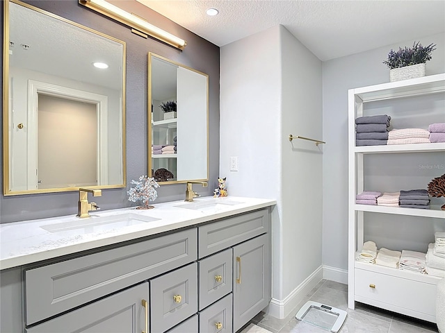 60 Surfview Dr Unit 308, Palm Coast, FL 32137 - bathroom with double vanity, a textured ceiling, and tile patterned flooring