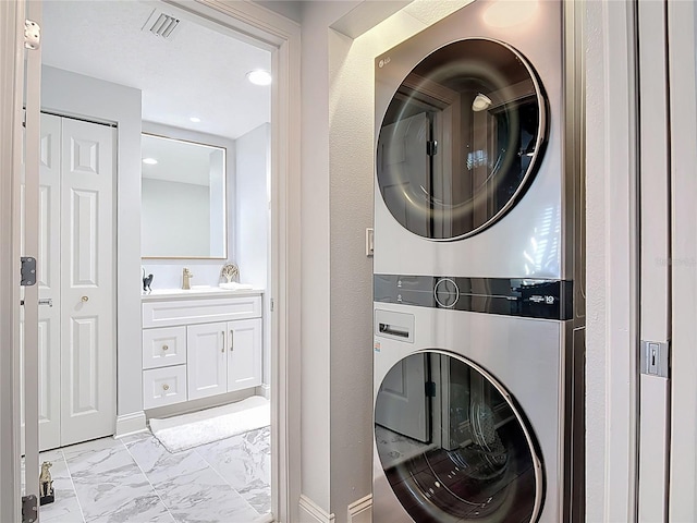 60 Surfview Dr Unit 308, Palm Coast, FL 32137 - laundry room featuring stacked washing machine and dryer, light marble finish floors, and recessed lighting