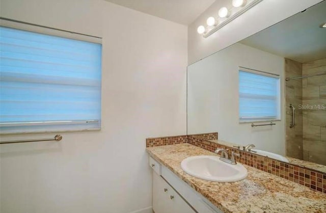 2813 21st Ave W, Bradenton, FL 34205 - bathroom featuring tiled shower, vanity, and backsplash