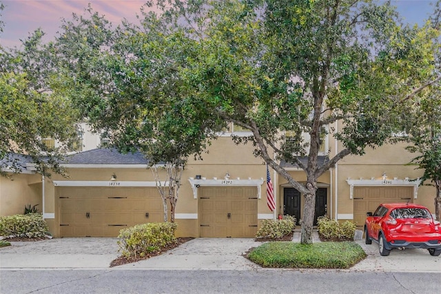 14242 Desert Haven St Unit Ge, Windermere, FL 34786 - obstructed view of property with stucco siding and a garage