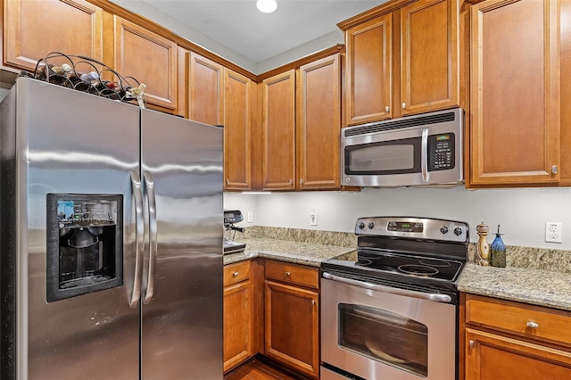 14242 Desert Haven St Unit Ge, Windermere, FL 34786 - kitchen featuring appliances with stainless steel finishes, light stone countertops, and brown cabinets
