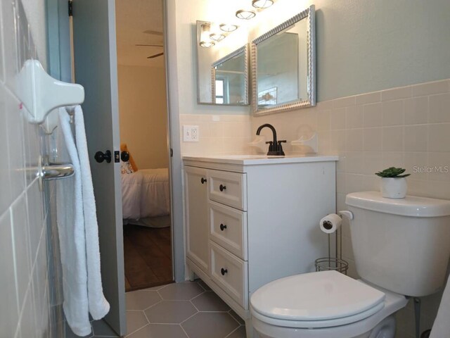 2257 World Parkway Blvd W Unit 61, Clearwater, FL 33763 - bathroom with vanity, tile walls, tile patterned flooring, and ensuite bath