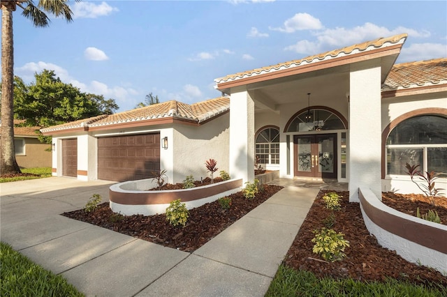 17032 Winners Cir, Odessa, FL 33556 - view of front of property with french doors, a tiled roof, stucco siding, a garage, and driveway