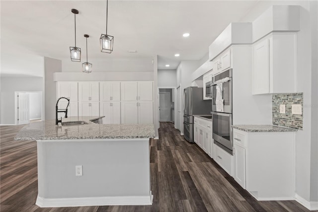17032 Winners Cir, Odessa, FL 33556 - kitchen featuring dark wood-style flooring, tasteful backsplash, a large island, white cabinets, and appliances with stainless steel finishes