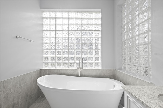 17032 Winners Cir, Odessa, FL 33556 - full bath with a freestanding bath, tile walls, plenty of natural light, vanity, and wainscoting