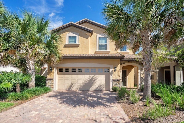 8901 Rhodes St, Kissimmee, FL 34747 - mediterranean / spanish-style house with stucco siding, a tiled roof, decorative driveway, and a garage