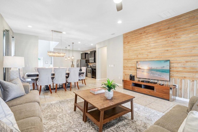 8901 Rhodes St, Kissimmee, FL 34747 - living area featuring light tile patterned floors, wooden walls, a chandelier, ceiling fan, and recessed lighting