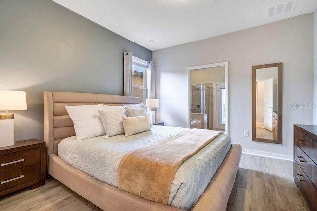 8901 Rhodes St, Kissimmee, FL 34747 - bedroom with light wood-type flooring and ensuite bath