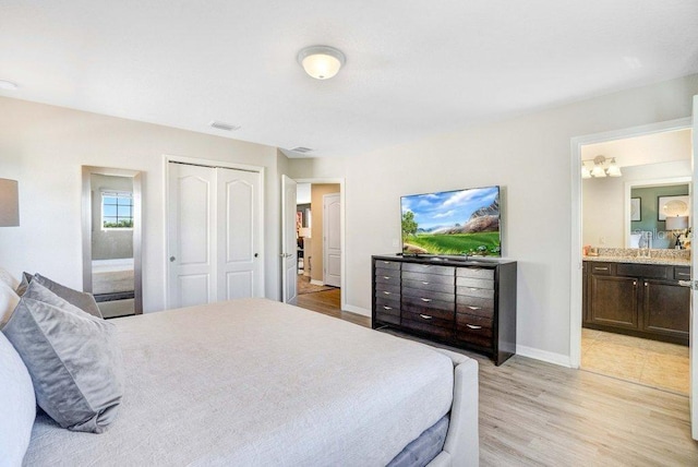 8901 Rhodes St, Kissimmee, FL 34747 - bedroom with light wood finished floors, ensuite bathroom, and a closet