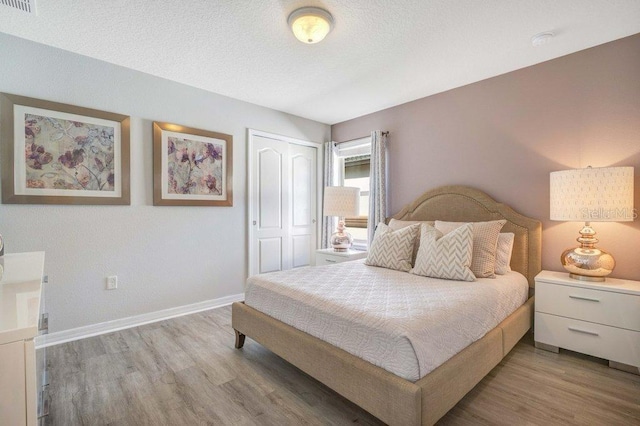 8901 Rhodes St, Kissimmee, FL 34747 - bedroom with light wood-type flooring, a closet, and a textured ceiling