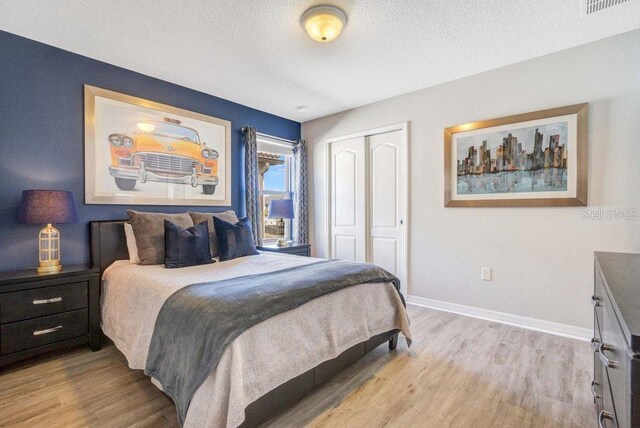 8901 Rhodes St, Kissimmee, FL 34747 - bedroom featuring a closet, light wood-style floors, and a textured ceiling