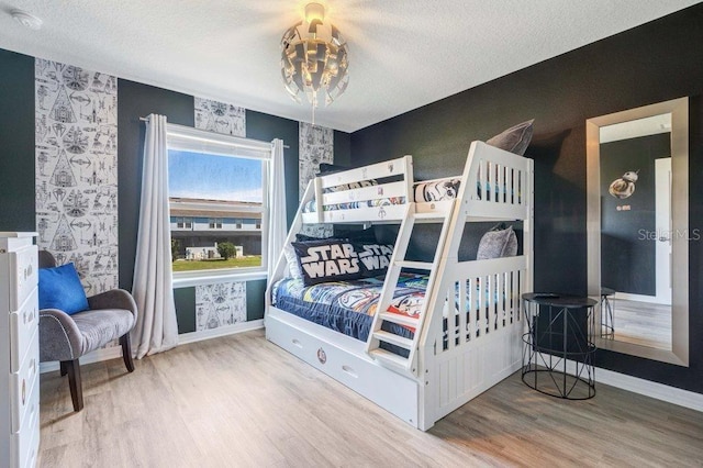 8901 Rhodes St, Kissimmee, FL 34747 - bedroom featuring wood finished floors, a chandelier, wallpapered walls, and a textured ceiling