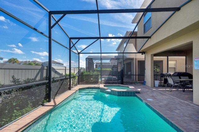 8901 Rhodes St, Kissimmee, FL 34747 - view of swimming pool featuring a patio area, a pool with connected hot tub, glass enclosure, and grilling area