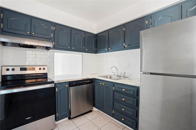 2850 N Powers Dr Unit 74, Orlando, FL 32818 - kitchen with stainless steel appliances, under cabinet range hood, blue cabinetry, decorative backsplash, and light tile patterned floors
